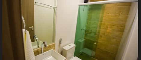 A bathroom with a sink, toilet, and glass-enclosed shower.