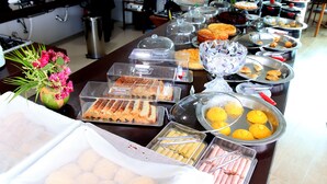 A buffet with various food items and a flower arrangement. - Star Hotel (Jijoca de Jericoacoara)