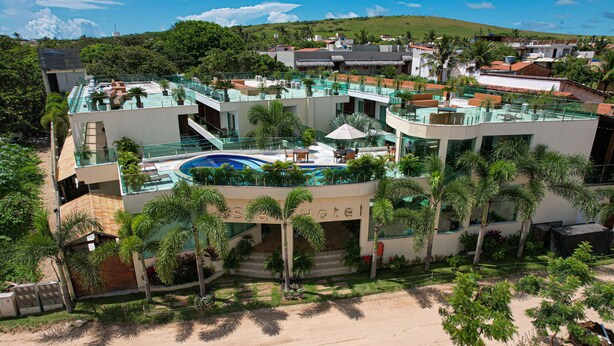 A modern hotel with a rooftop pool, palm trees, and a view of the surrounding landscape. - Star Hotel (Jijoca de Jericoacoara)