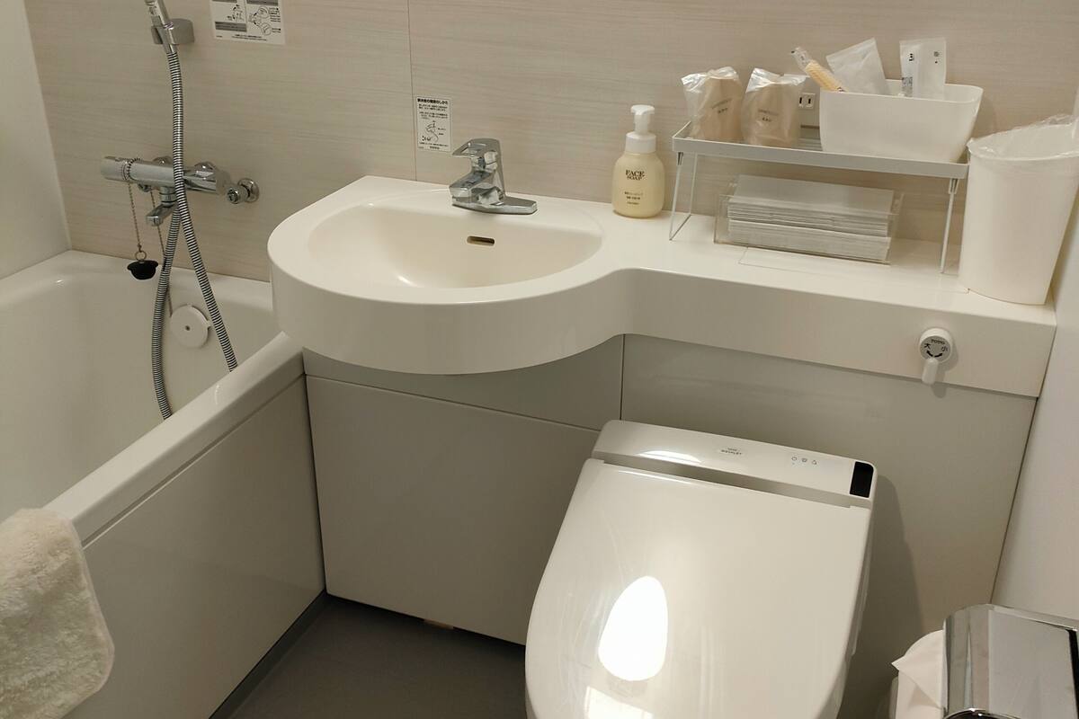 Ein Badezimmer mit einer Badewanne, einem Waschbecken, einer Toilette und einem Spiegel.