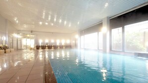An indoor swimming pool with tiled walls and a tiled floor, a changing room area with benches, and large windows allowing natural light. - Yunomiko Onsen (Kamiichi)