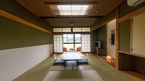 A traditional Japanese room with tatami flooring, a low table, and sliding doors. - Yunomiko Onsen (Kamiichi)