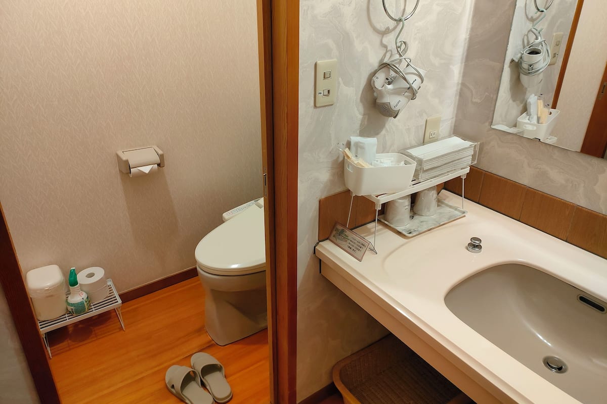 Ein Badezimmer mit Toilette, Waschbecken und Duschbereich.