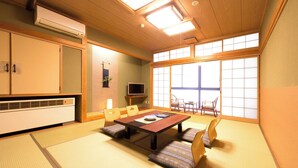 A traditional Japanese room with tatami flooring, a low table, and sliding doors. - Yunomiko Onsen (Kamiichi)