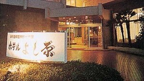 A building with a sign in front that reads "Hotel". - Hotel Yoshihara (Toyama)