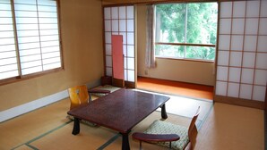 A traditional Japanese room with tatami flooring, a low table, and shoji screens. - Kogakuro (Myoko)