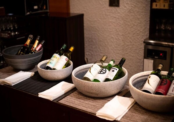 A bar area with multiple bowls containing bottles of wine. - Hotel Fuuka (Hokuto)