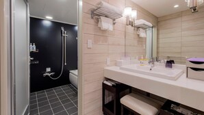 Une salle de bain moderne équipée d’une douche, de toilettes et d’un meuble-lavabo avec un évier et un miroir.