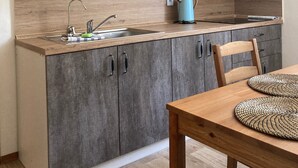 Una cocina moderna con armarios grises, encimera de madera, un lavabo y un hervidor azul.