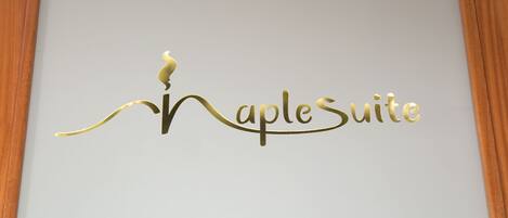 A logo with the text "Naples Suite" in a stylized font.