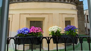 Un edificio con una cupola verde e un campanile. Davanti all'edificio, vasi pieni di fiori.