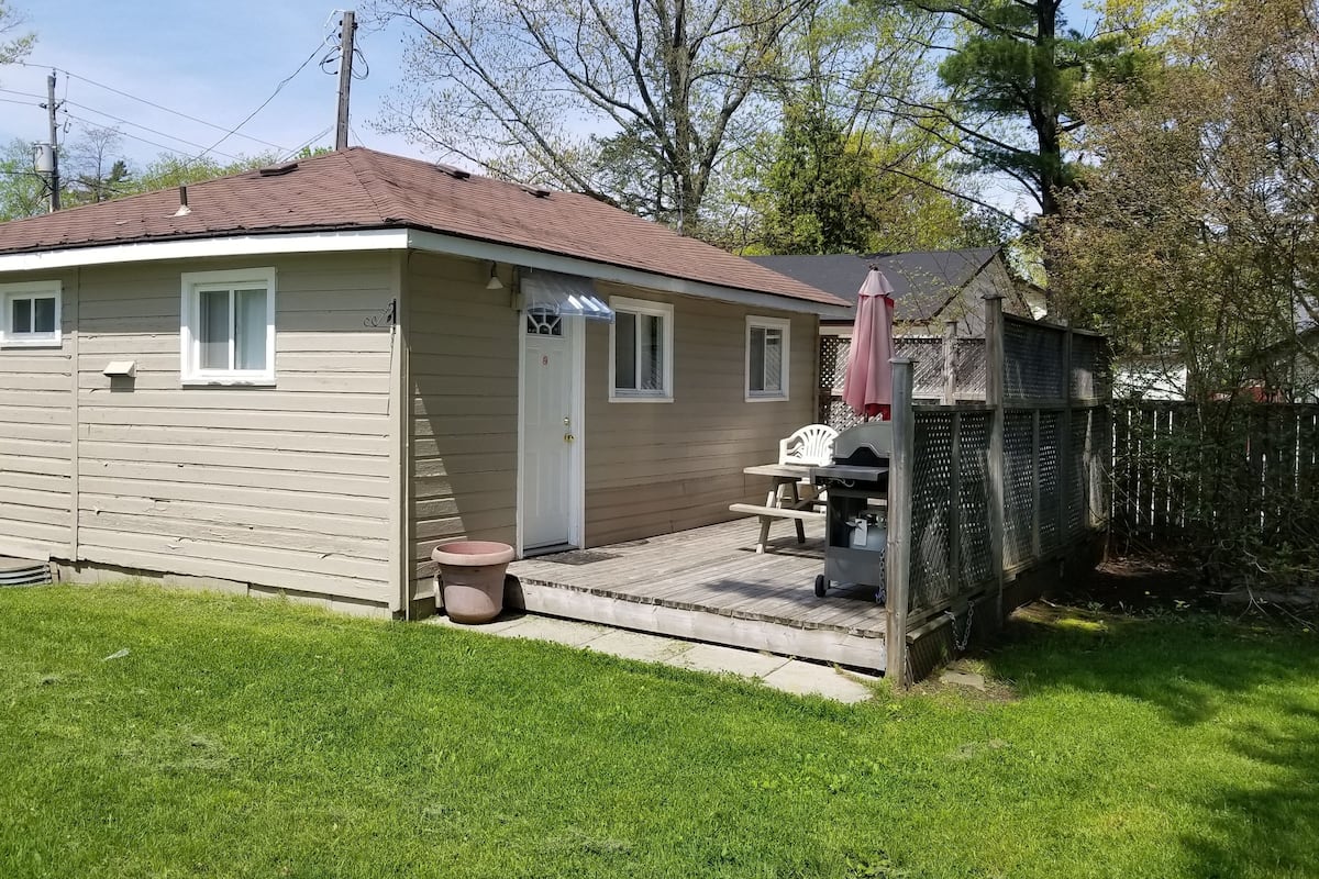 A single-story house with a front porch, a small patio, and a grill area.