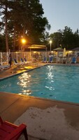 Una piscina al aire libre de temporada, sillones reclinables de piscina