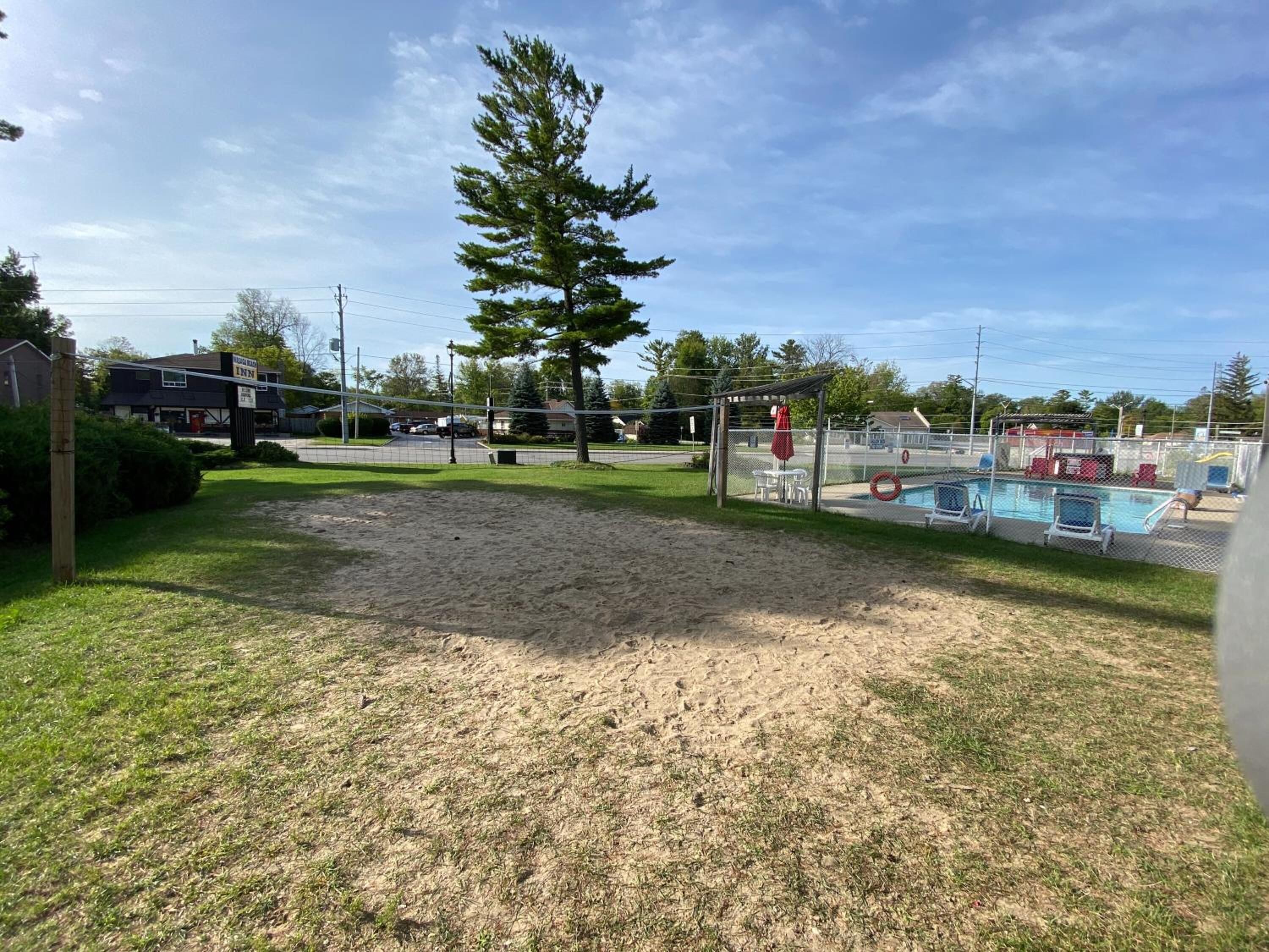 A fenced outdoor area with a pool, a covered seating area, and a building labeled "Inn".