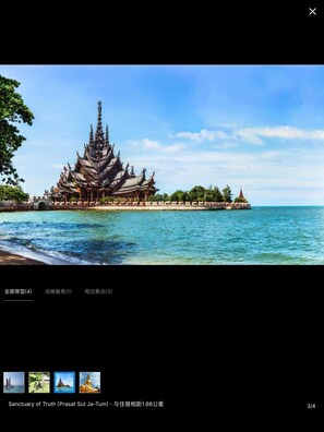 A traditional temple with a multi-tiered roof, located near a body of water.