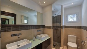 A modern bathroom with two sinks, a shower, and a toilet. - Villa Pinel – Intimate Oceanview Escape Above Orient Bay, St. Martin (Cul-de-Sac)