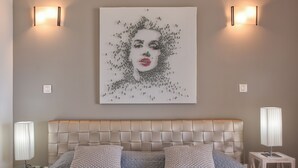 A bedroom with a tufted headboard, two bedside tables with lamps, and a large abstract artwork on the wall. - Villa Pinel – Intimate Oceanview Escape Above Orient Bay, St. Martin (Cul-de-Sac)