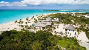 A beachfront property with several villas, a swimming pool, and lush greenery. - Hawksbill Estate – A Grand Beachfront Estate on Grace Bay, Turks & Caicos (Leeward Settlement)