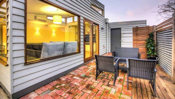 A patio with a table and chairs, a window with a view, and a door. - 5 Connelly - Echuca Holiday Homes (Echuca)
