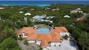 Oversigtsbillede af et resort med flere bygninger, en swimmingpool og havudsigt.