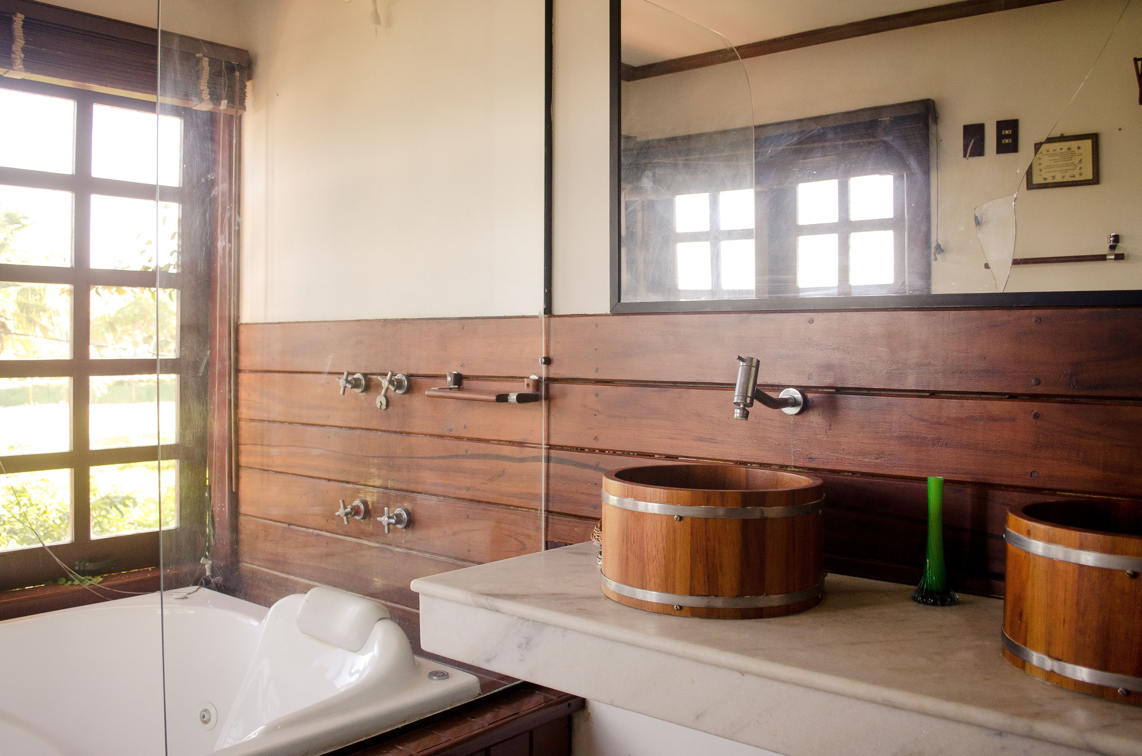 A bathroom with a wooden vanity, a bathtub, and a large mirror.