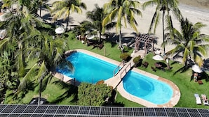 Un resort con piscina, playa y vista al océano.