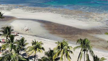 Na praia, guarda-sóis, toalhas de praia