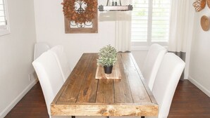 A dining table with white chairs, a potted plant, and a decorative wall piece. - The Sycamore Bungalow located near attractions in The Amish Country.  (Lancaster)