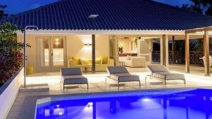 Et poolområde med liggestole, en overdækket terrasse og en pool.