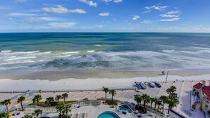 Ein Strandresort mit Pool, Liegestühlen und Blick aufs Meer.