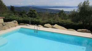 Ein Schwimmbad mit Blick auf Berge und einen See.