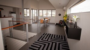 Una cocina moderna con comedor, una escalera y vistas al exterior.
