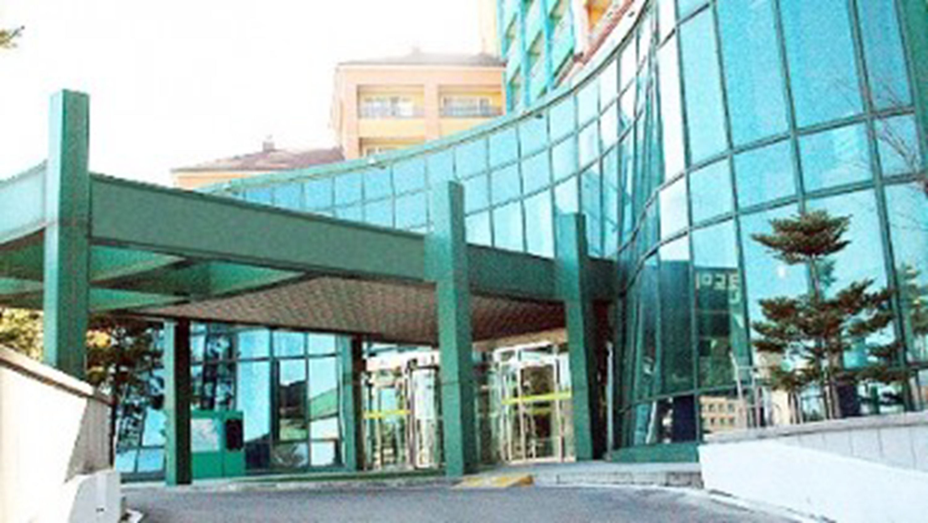 Um edifício moderno com fachada de vidro e área de entrada coberta.