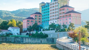 A multi-story hotel with a unique architectural design, featuring a mix of pastel colors and a prominent tower structure.