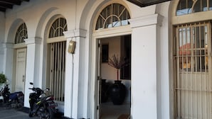 A building with arched windows, a gated entrance, and several vases. - Hotel DeQur Jakarta Kota (Jakarta)