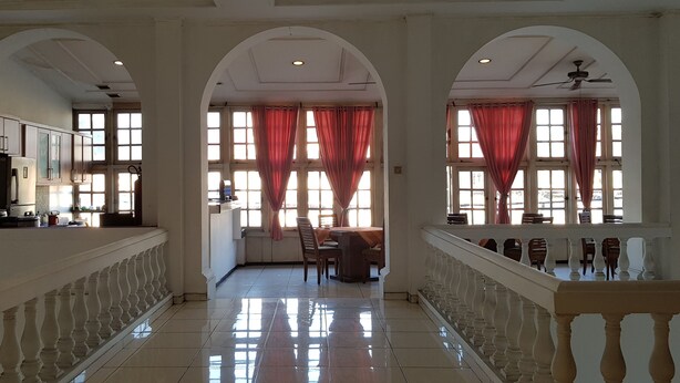 A spacious hallway with a kitchen area on the left, a dining area in the center, and a seating area on the right. - Hotel DeQur Jakarta Kota (Jakarta)