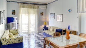 A living room with a sofa, a TV, a table, and a lamp. - TYSANDROS - SEA VIEW (Giardini-Naxos)