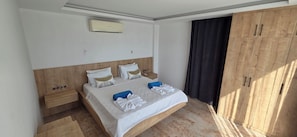 Een hotelkamer met een bed, een kledingkast, een nachtkastje en een airconditioning.