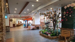 A spacious lobby with a bakery counter, seating areas, and a decorative floral arrangement. - Yangji Pine Resort (Yongin)