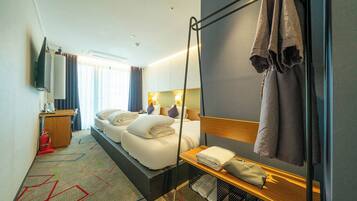 A hotel room with a bed, bedside table, and a large mirror.