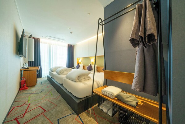 A hotel room with a bed, bedside table, and a large mirror. - South Vandeco Hotel (Busan)