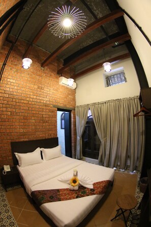 A hotel room with a brick wall, a bed with white linens, a hanging light fixture, and a small window with curtains. - Ban Loong Hotel (Ipoh)