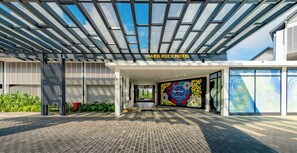 The Hard Rock Hotel entrance with a modern design, including a glass facade and a colorful mural.