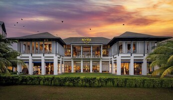 Un hotel con un atrio central, varios pisos y un jardín ajardinado en la fachada.