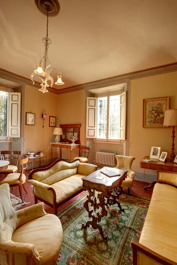A traditional room with a sofa set, a table, and a chandelier.