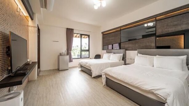 A modern hotel room with two beds, a flat-screen TV, a small desk, and a window with curtains. - Jophina B&B (Donggang)