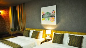 A hotel room with two beds, a brick wall, a painting, and a nightstand with a lamp. - Valya Hotel - Kuala Terengganu (Kuala Terengganu)