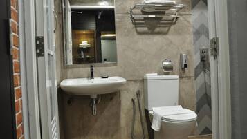 Ein kleines Badezimmer mit Waschbecken, Toilette und Dusche.