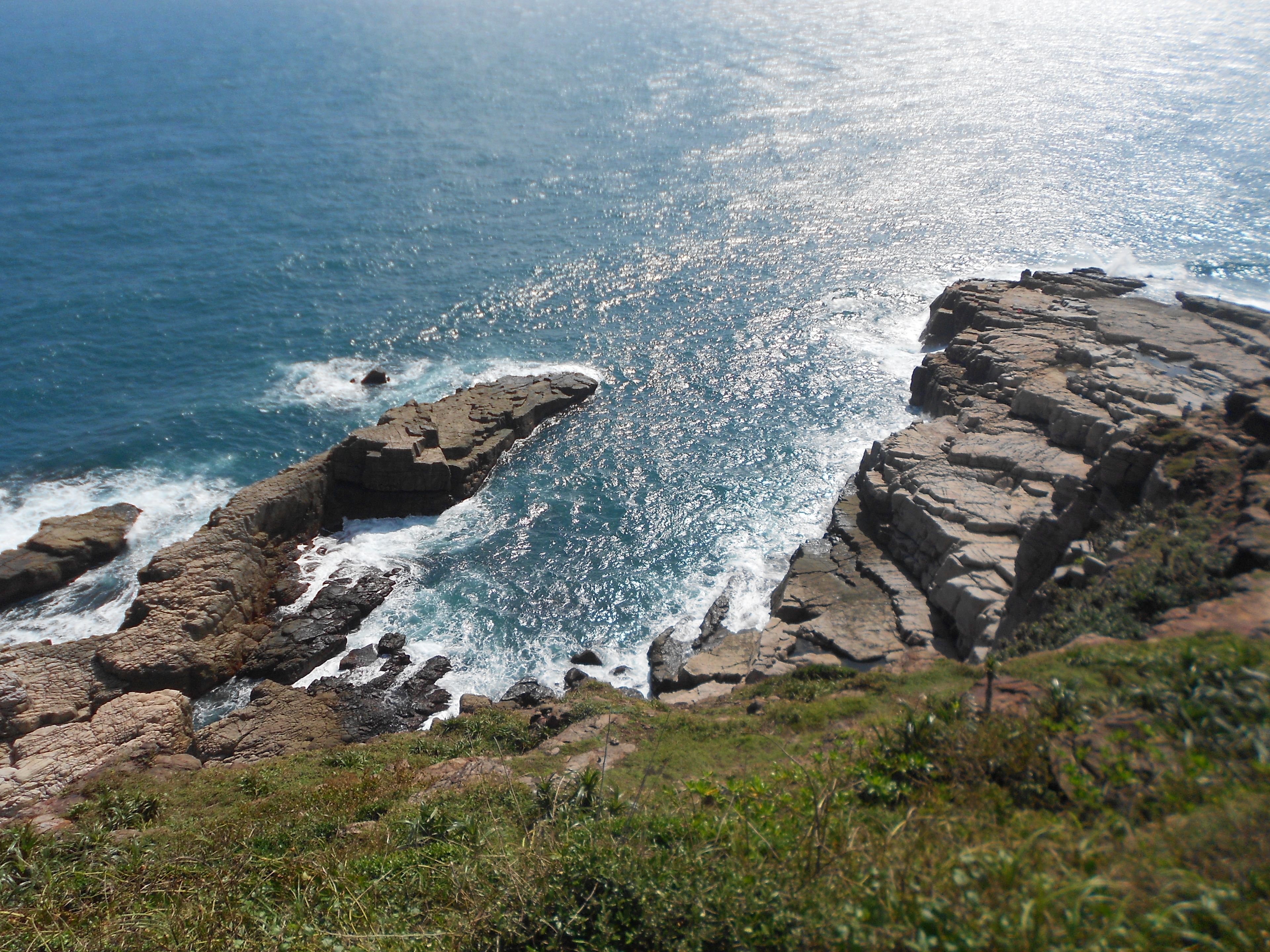 A rocky coastline with waves crashing against the rocks.
