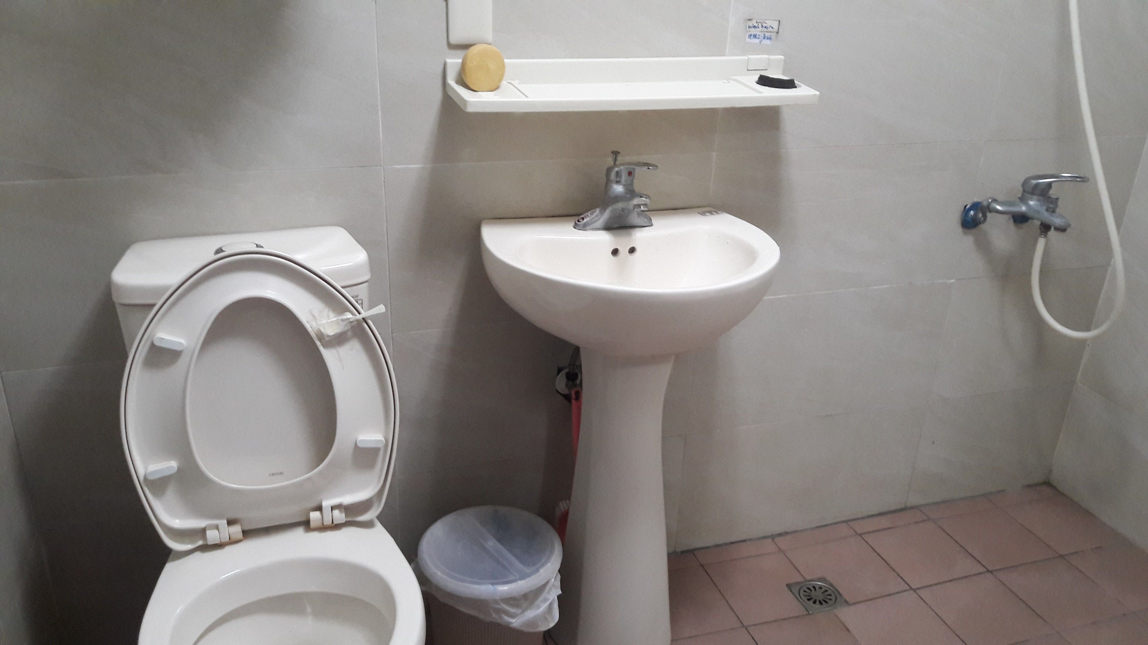 A bathroom with a toilet, sink, and shower.